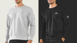 Two crewneck sweatshirts side by side, one light gray and the other black, both featuring a small mountain logo on the chest and a subtle flag design on the right sleeve.